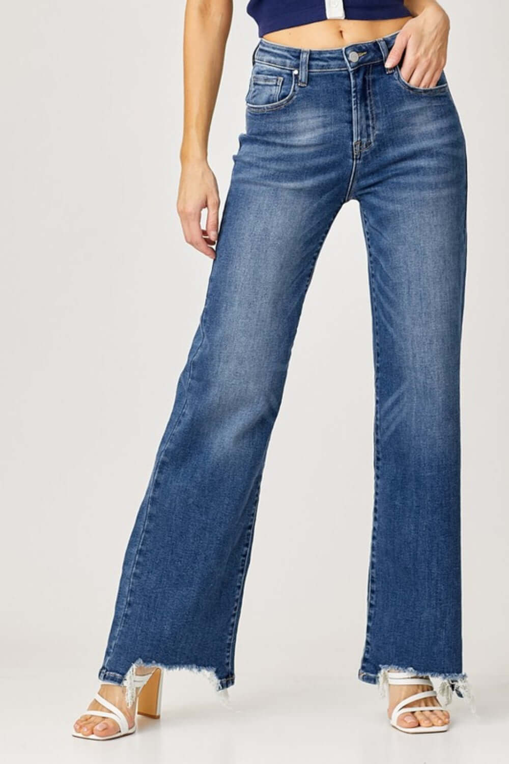 Woman wearing high-rise frayed hem wide leg jeans by Risen Jeans showing off trendy and stylish look for casual outings or dressed-up occasions.