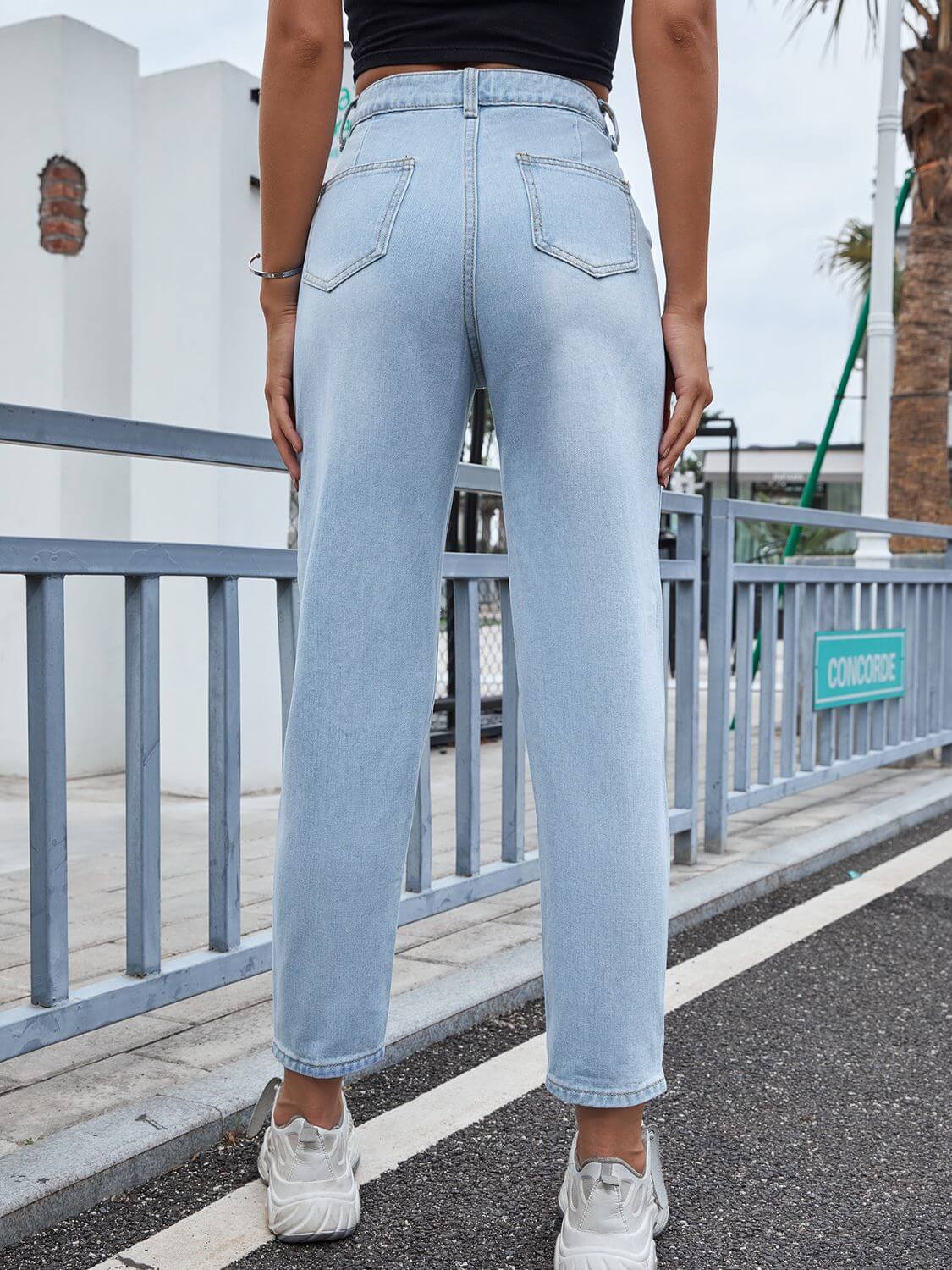 Woman wearing Bella Road Distressed Straight Jeans with pockets, view from behind on sidewalk