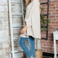 Cozy Bella Road Batwing Sleeve Sweater styled with jeans and sneakers in a chic room setting.