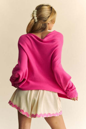 Pink batwing sleeve sweater paired with cream shorts, perfect for a comfy and stylish look.