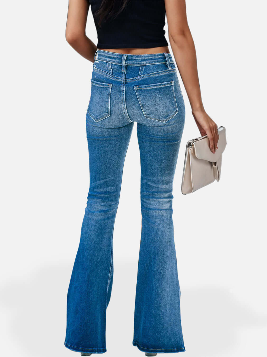 Back view of person wearing blue button fly bootcut jeans with pockets, holding a clutch bag, showcasing slightly stretchy denim fabric.