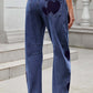 Back view of Bella Road Denim Heart Mid Rise Jeans with whimsical heart design and pockets, perfect for casual style.