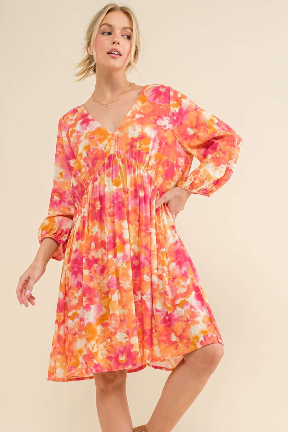 Woman wearing a colorful full-size printed tie-back long sleeve dress with a floral design, ideal for day to night transitions.