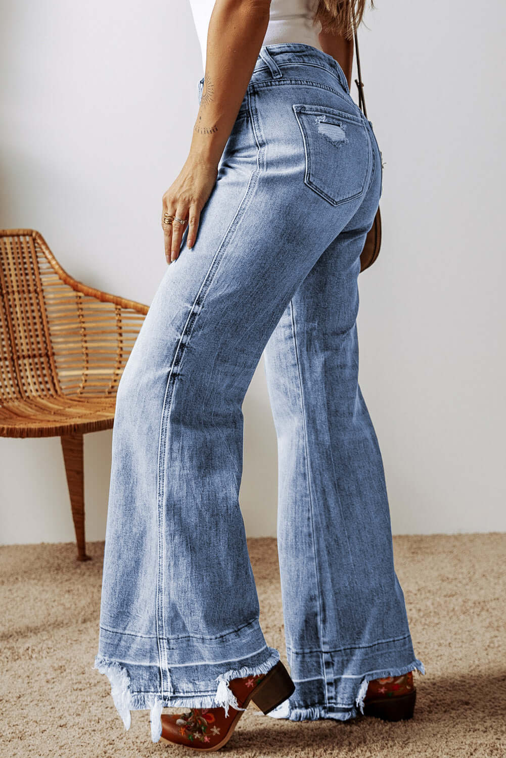 Petite raw hem bootcut jeans with pockets, back view. Stylish and functional jeans for petite women, featuring playful raw hems and a slight stretch.