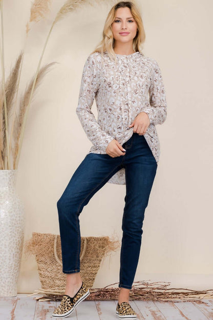 Model wearing a stylish leopard print blouse with jeans and sneakers, showcasing trendy casual fashion.