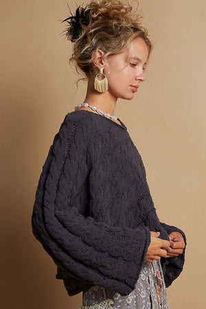 Woman wearing a POL round neck cable knit cropped sweater with full sleeves, showcasing a cozy chenille texture and trendy design.