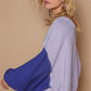 Stylish model showcasing a cozy POL Exposed Seam Contrast V-Neck Lantern Sleeve Sweater in lavender and blue.