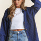 Woman wearing J.NNA rhombus stitched denim shacket over white tee, showcasing stylish oversized fit and button-up design.