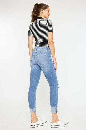 Woman wearing Distressed Cat's Whiskers Button Fly Jeans with cuffs and a striped top, showcasing a casual chic style.