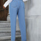 Stylish woman in medium wash straight leg jeans featuring a comfortable waistband and chic design, posing on stairs.