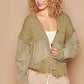 Stylish woman in an olive green distressed hem button-up hooded cardigan, showcasing casual comfort and trendy warmth.