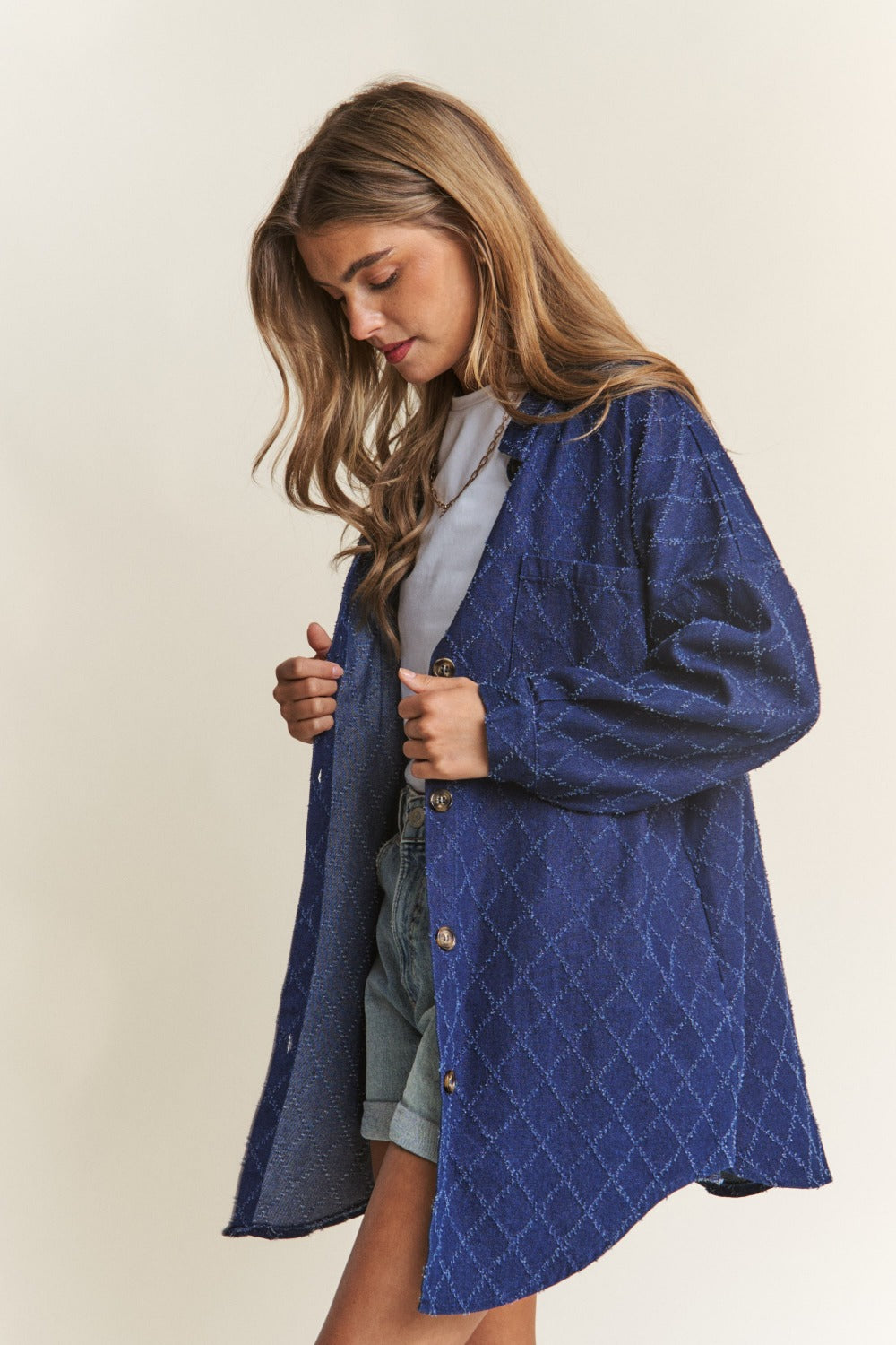 Woman wearing J.NNA rhombus stitched button-up denim shacket, showcasing its stylish oversized fit and unique stitching.