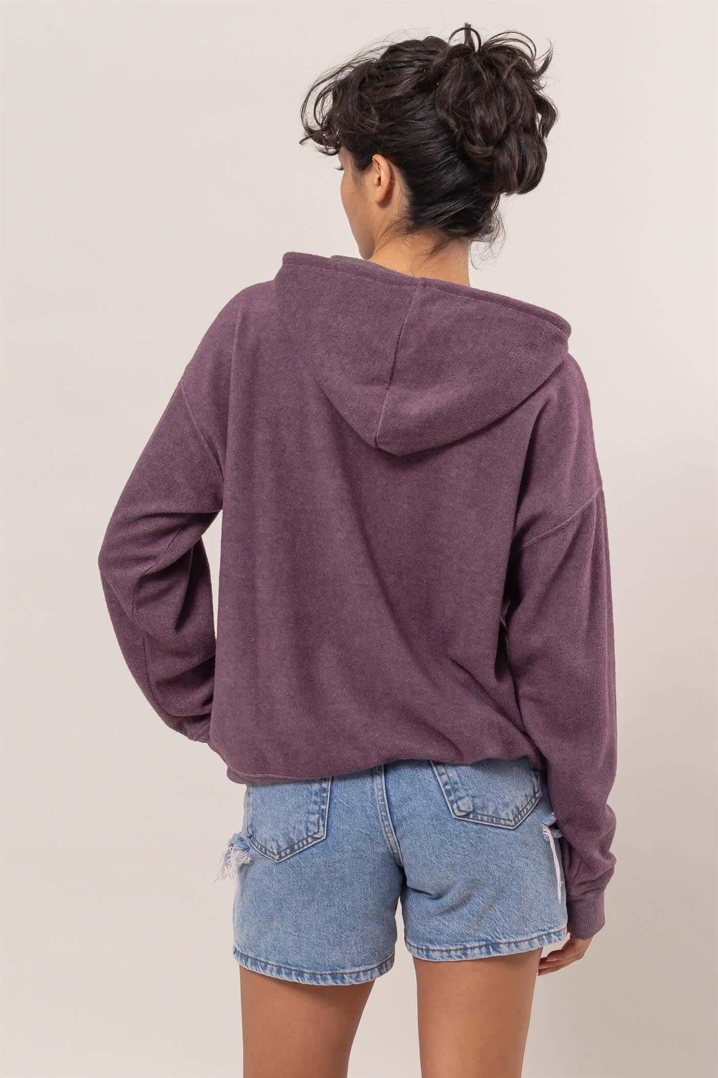 Cozy purple brushed hoodie with kangaroo pocket, perfect for casual days and lounging, styled with denim shorts.