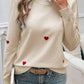 Devine Lace Detail Heart Long Sleeve Sweater in cream with red heart designs and blue jeans