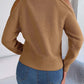 Woman wearing Bella Road Cable-Knit Cold Shoulder Turtleneck Sweater in tan, paired with jeans, trendy and cozy style.