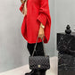 Woman wearing red Bella Road batwing sleeve sweater with quilted purse and boots.