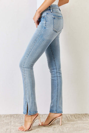 Woman wearing Mid Rise Y2K Slit Bootcut Jeans in light blue, showcasing side slit detail and paired with high heels for a stylish look