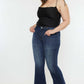 Woman modeling Kancan Full Size Mid Rise Slim Flare Jeans in dark stone wash, showing a chic and versatile denim style.