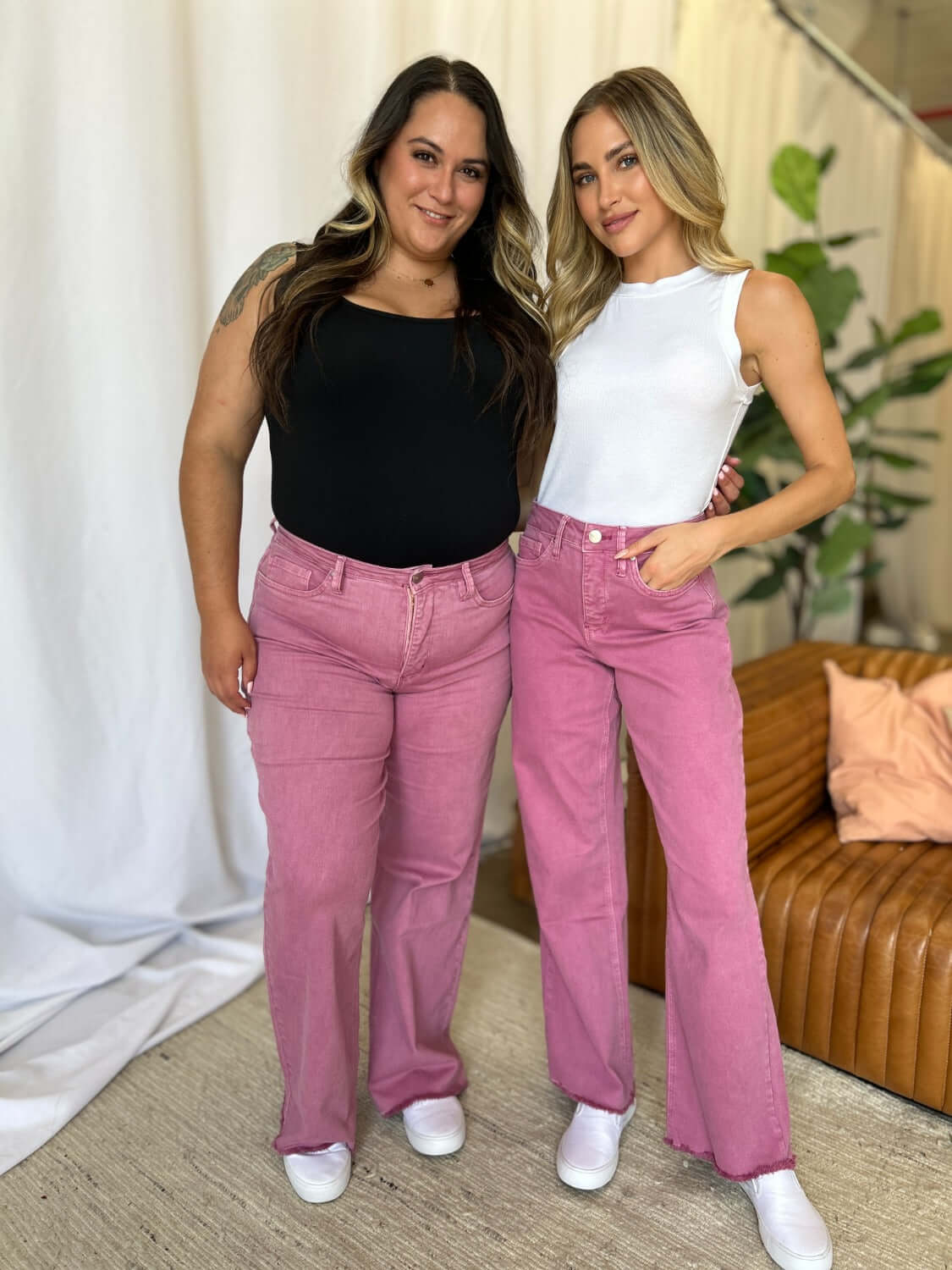 Two women modeling RFM Full Size High Rise Garment Dye Wide Leg Jeans in pink, showcasing stylish high-waist fit with relaxed, wide-leg silhouette.