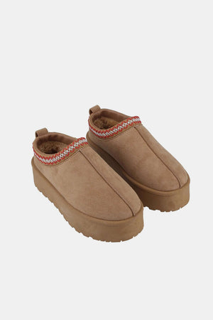 Trendy beige platform slip-on boots with embroidered trim, offering style and comfort for daily wear.