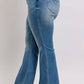 Model showcasing Judy Blue Mid Rise Tummy Control Vintage Wash Jeans with stylish black heels.