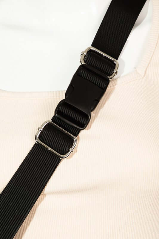 Adjustable black strap with silver hardware on a trendy sling bag, showcasing its stylish design and functionality.