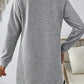 Woman wearing a Bella Road textured gray long sleeve mini dress, showcasing a relaxed fit and stylish pattern.