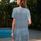 Back view of a woman in a blue openwork cover-up near a pool, showcasing summer style and comfort.