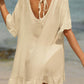 Woman wearing a sheer, ruffled tied half sleeve cover-up on the beach, made of 65% cotton and 35% polyester. No stretch fabric.