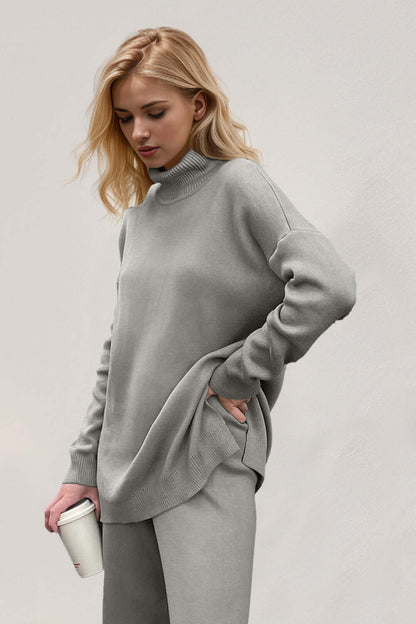 Woman wearing Basic Bae Side Slit Turtleneck Sweater, cozy chic style with dropped shoulders, holding a cup against a neutral background.