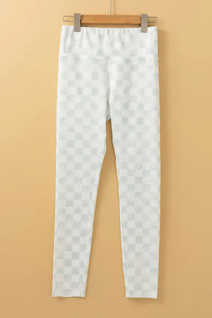 Bella Road white checkered elastic waist leggings hanging on a wooden hanger against a beige background