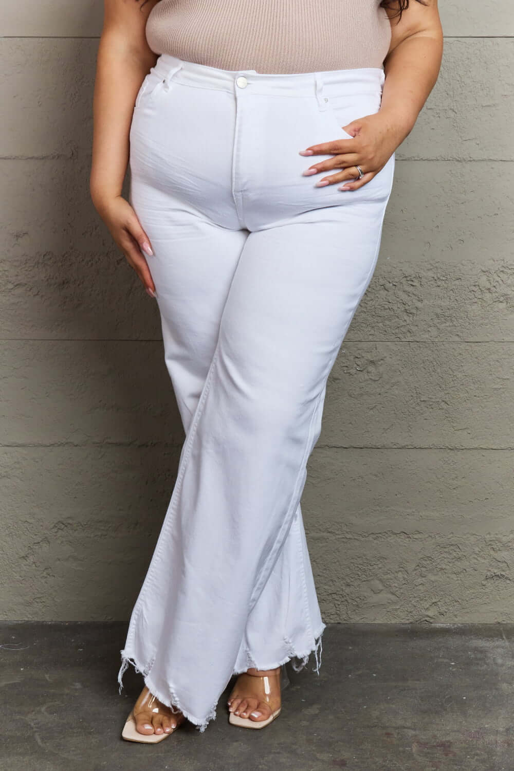 Woman wearing Raelene High Waist Wide Leg Jeans in White from Risen Jeans, showing chic retro flair with wide-leg design and high-rise waistline