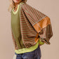 Woman wearing BiBi Color Block Striped Round Neck Sweatshirt with bold stripes in green, orange, and brown, styled with jeans.