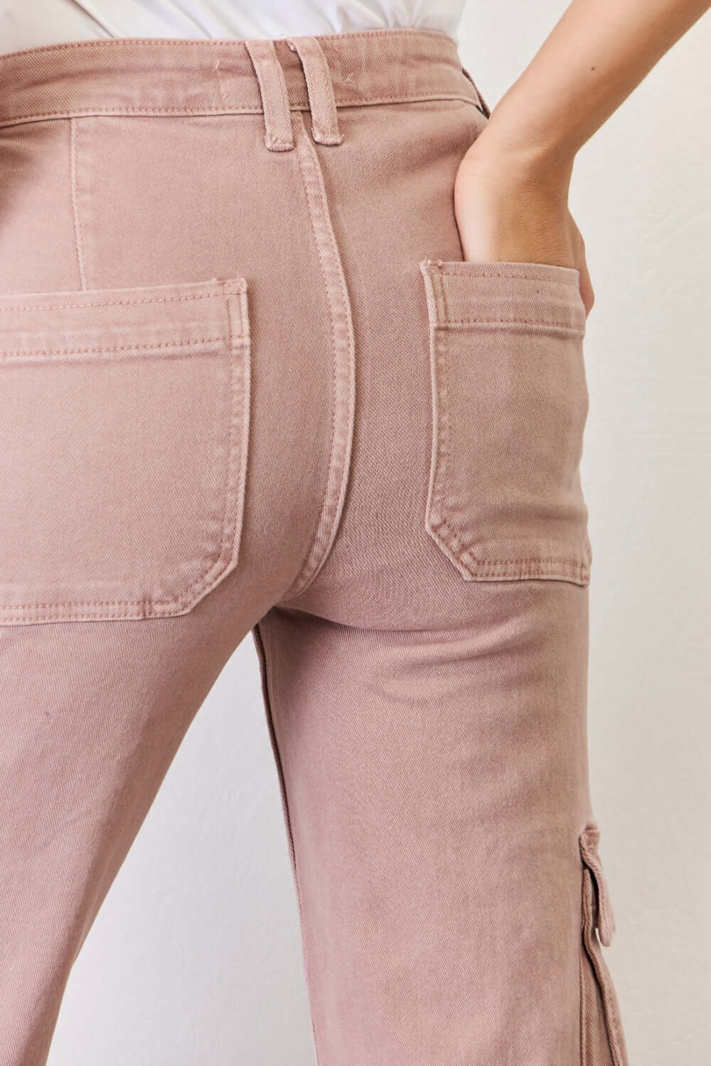 Back view of RISEN full-size high rise cargo wide leg jeans showcasing functional pockets in a flattering fit.