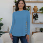 Woman wearing blue FAM-FAM round neck long sleeve t-shirt with decorative buttons, perfect for casual occasions.