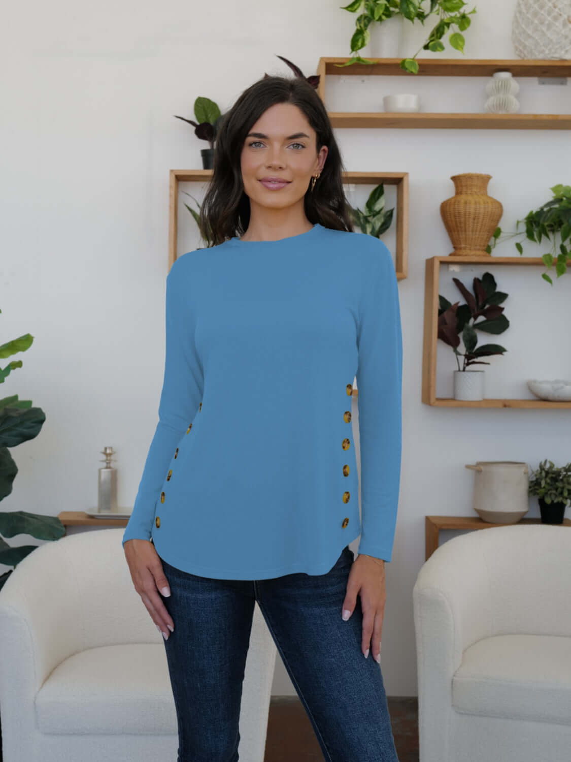 Woman wearing blue FAM-FAM round neck long sleeve t-shirt with decorative buttons, perfect for casual occasions.