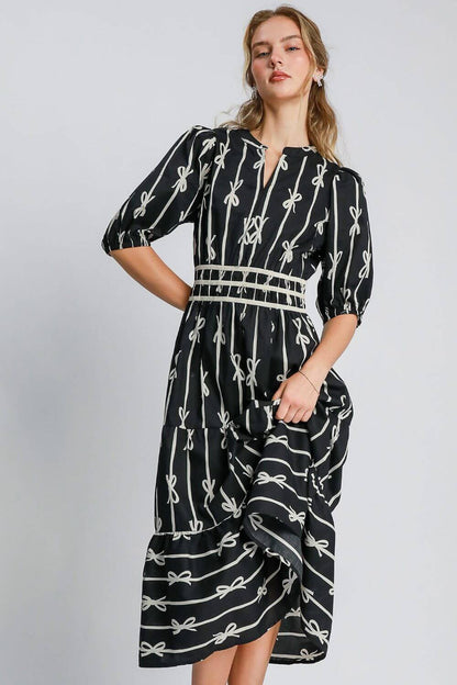 Elegant Umgee bow tie print midi dress with velvet trim, featuring a unique notched neckline and stylish silhouette.