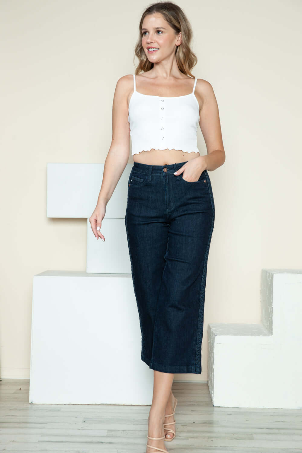 Woman wearing Judy Blue side seam braid detail crop wide leg jeans with white top.