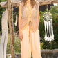 Woman wearing a button-up vintage wash vest with crochet patches and peach pants, standing outdoors with a dreamcatcher in the background.