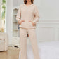 Woman wearing Bella Road eggshell hoodie and pants set in cozy room.