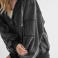 Trendy black zip-up drawstring hooded jacket with exposed seams and stylish pocket detail, perfect for cool weather.