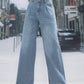 Trendy wide leg jeans with pockets, buttoned and slightly stretchy, made from 85% cotton and 15% polyester, perfect for a stylish street look.