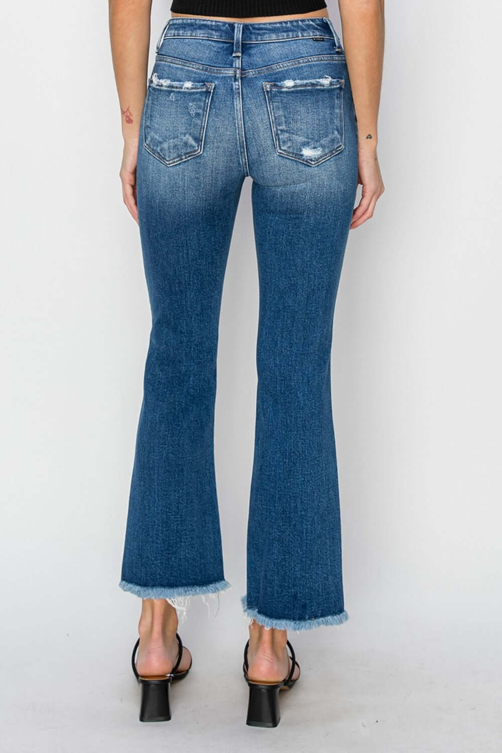 Model wearing Risen Jeans frayed step hem ankle straight jeans, showcasing back view with trendy distressed details and frayed hems.