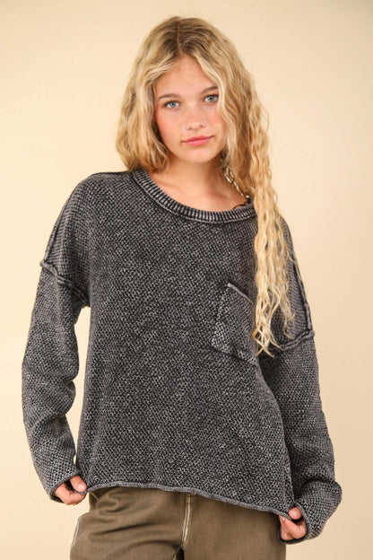 Woman wearing very J mineral washed exposed seam sweater with patch pocket, round neck, drop shoulder design, and long sleeves.