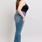 Model showcasing Judy Blue mid-rise tummy control vintage wash jeans, highlighting stylish fit and retro charm.