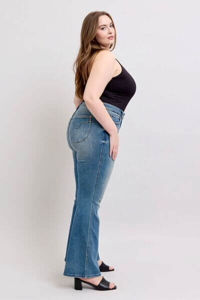 Model showcasing Judy Blue mid-rise tummy control vintage wash jeans, highlighting stylish fit and retro charm.