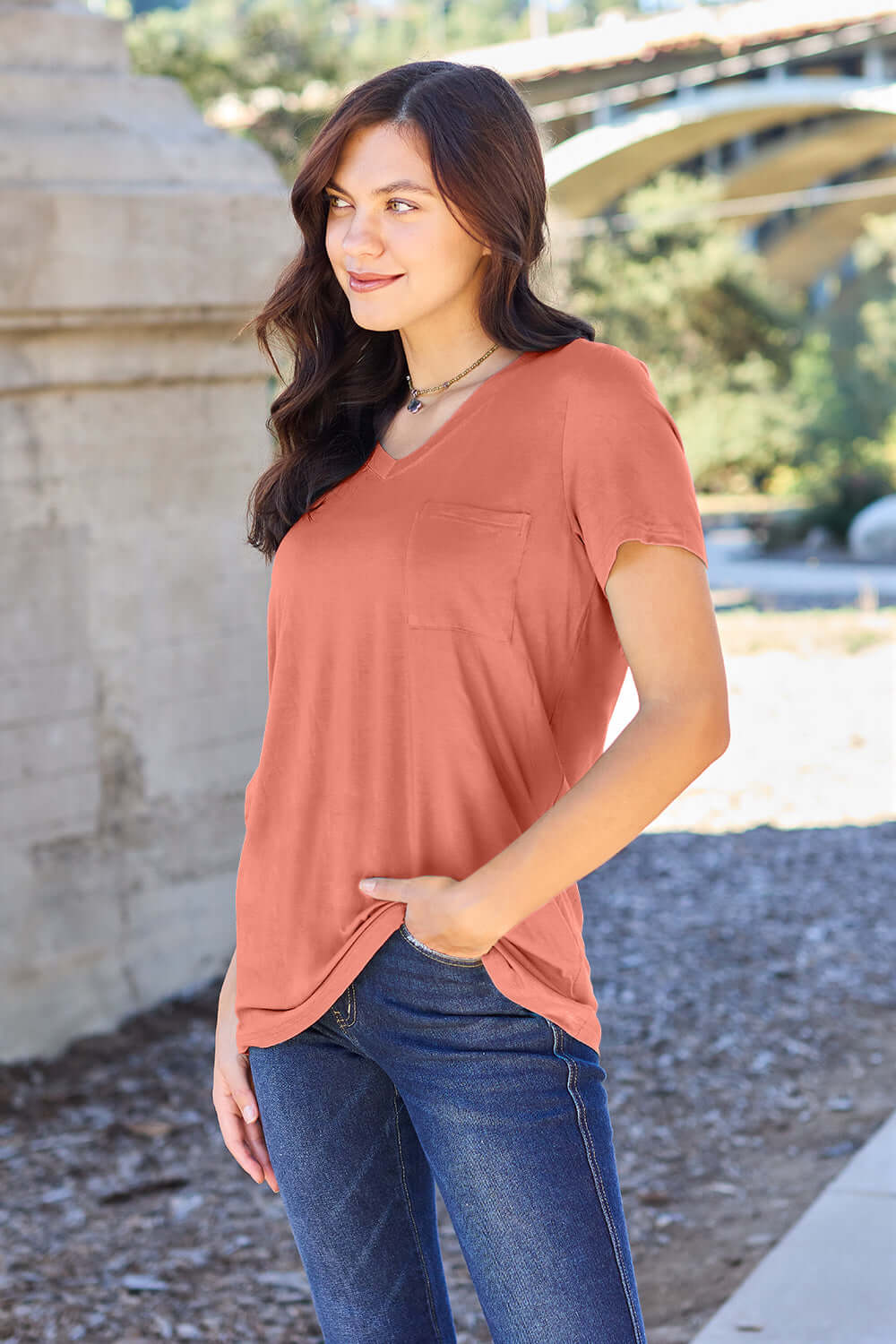 Woman wearing Basic Bae Bamboo V-Neck Short Sleeve T-Shirt in outdoor setting.