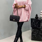 Woman wearing Bella Road Round Neck Batwing Sleeve Sweater in pink, paired with black boots and handbag.