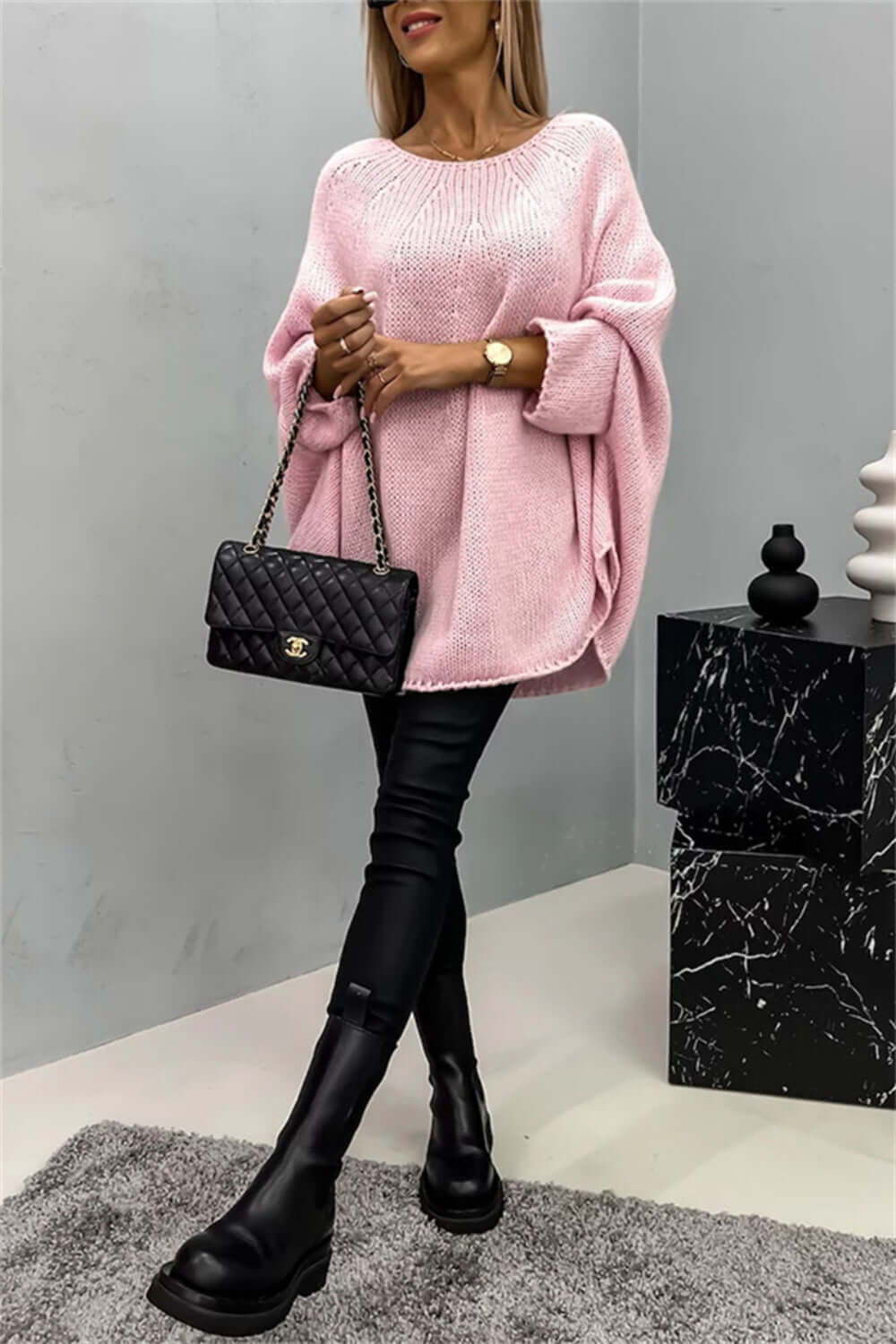 Woman wearing Bella Road Round Neck Batwing Sleeve Sweater in pink, paired with black boots and handbag.