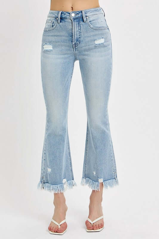 Plus size raw hem distressed cropped flare jeans in light wash, perfect for showcasing stylish footwear.